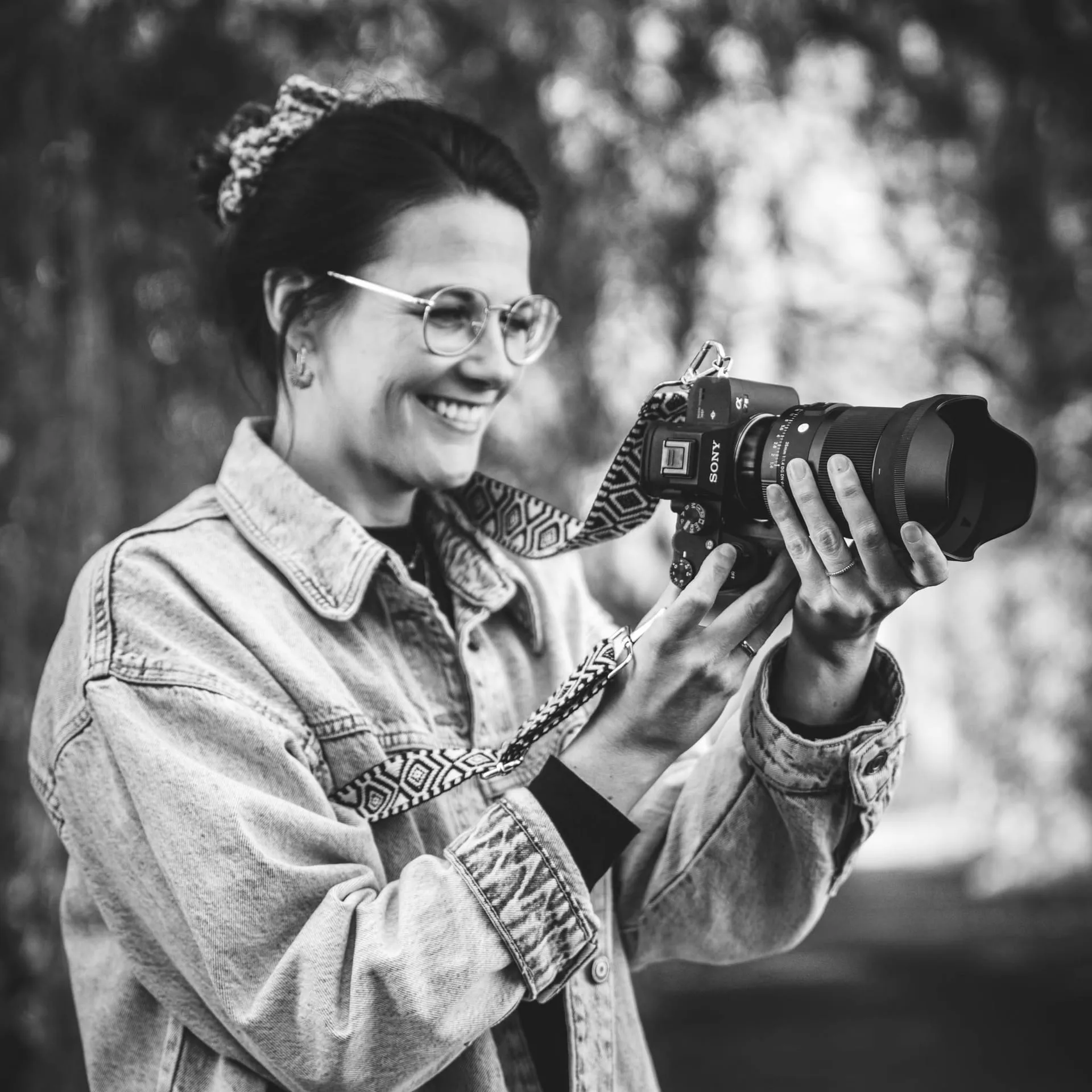 Anna Haupt fotografiert lachend mit ihrer Kamera, Schwarzweißaufnahme.