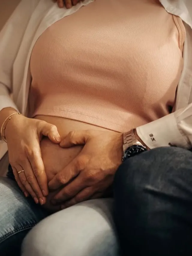 Zwei Hände liegen auf einem Babybauch.